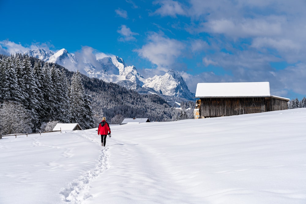 Eine Person in einer roten Jacke läuft durch den Schnee