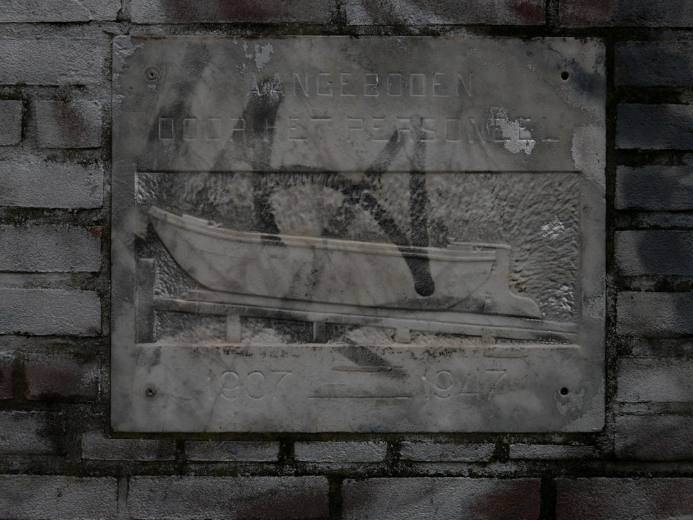a plaque on a brick wall with a picture of a boat