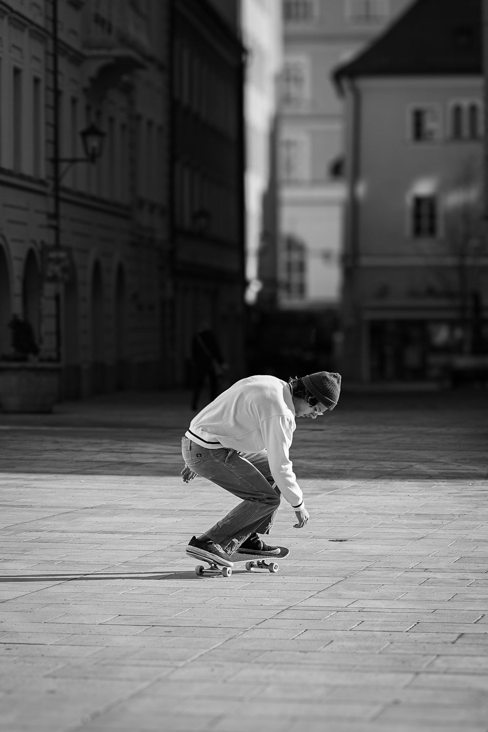 a man riding a skateboard down a street next to tall buildings