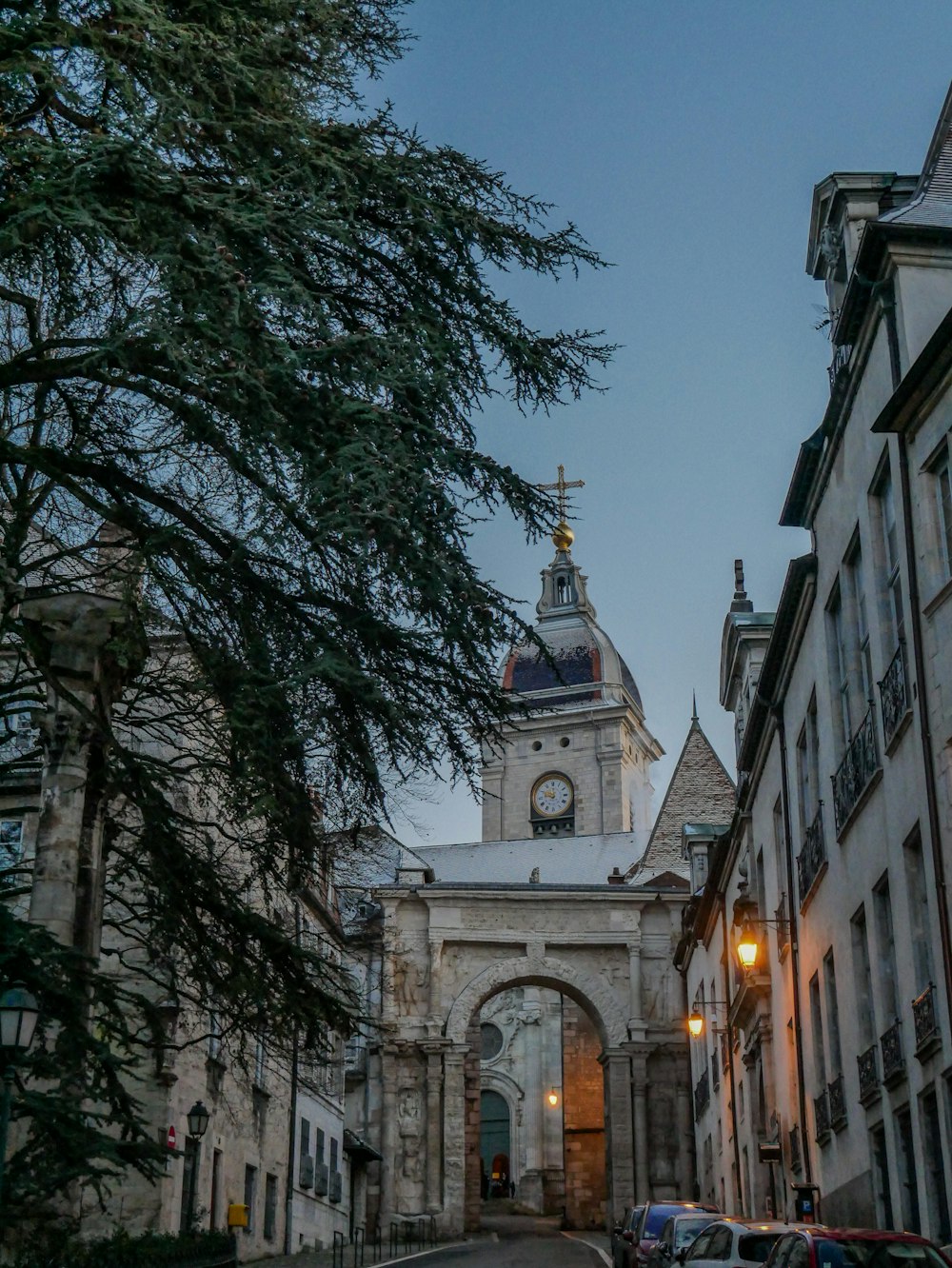 a street with cars parked on the side of it and a clock tower in the