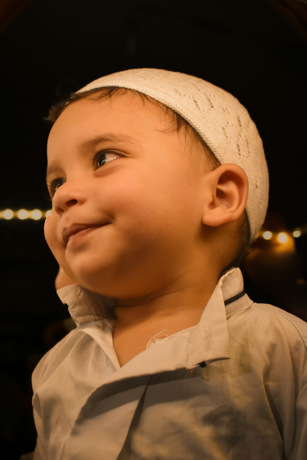 un petit garçon avec un bandeau blanc souriant