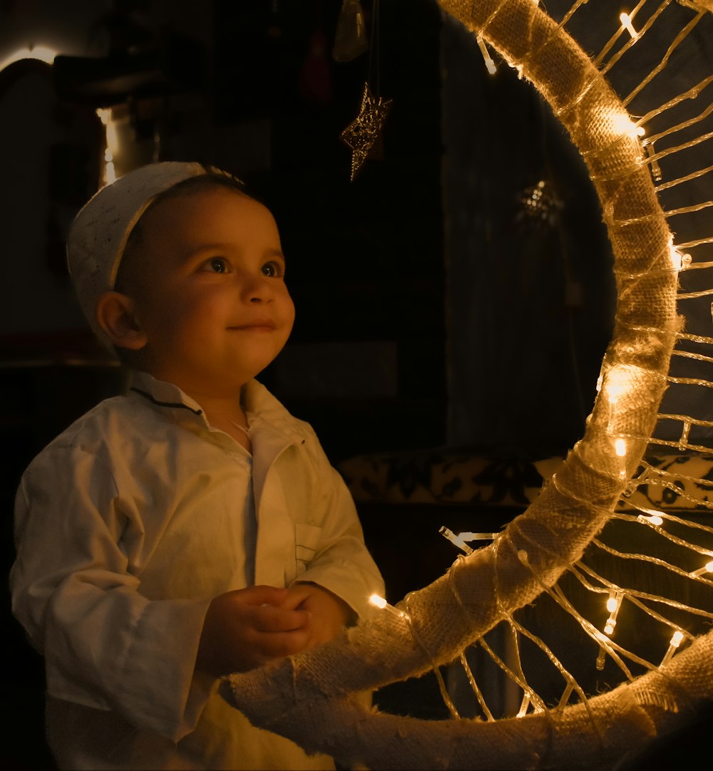 a little boy that is standing in front of a fan