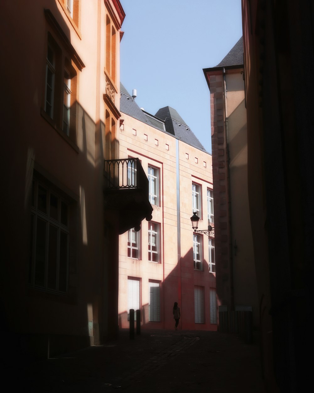 a person walking down a street next to tall buildings