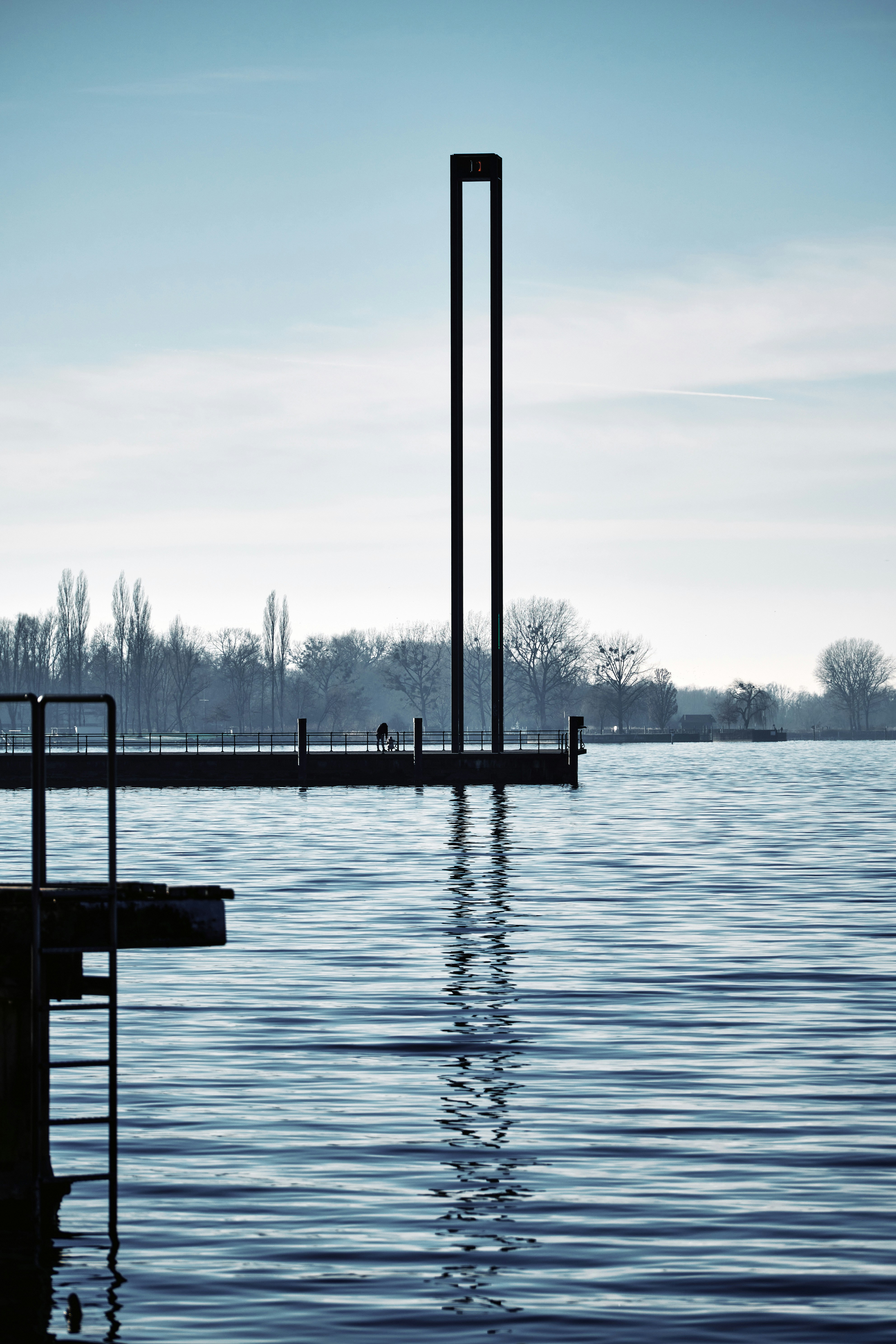 A body of water next to a pier photo – Free Human Image on Unsplash