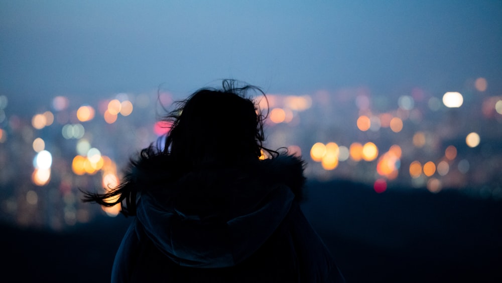 a person standing in front of a city at night