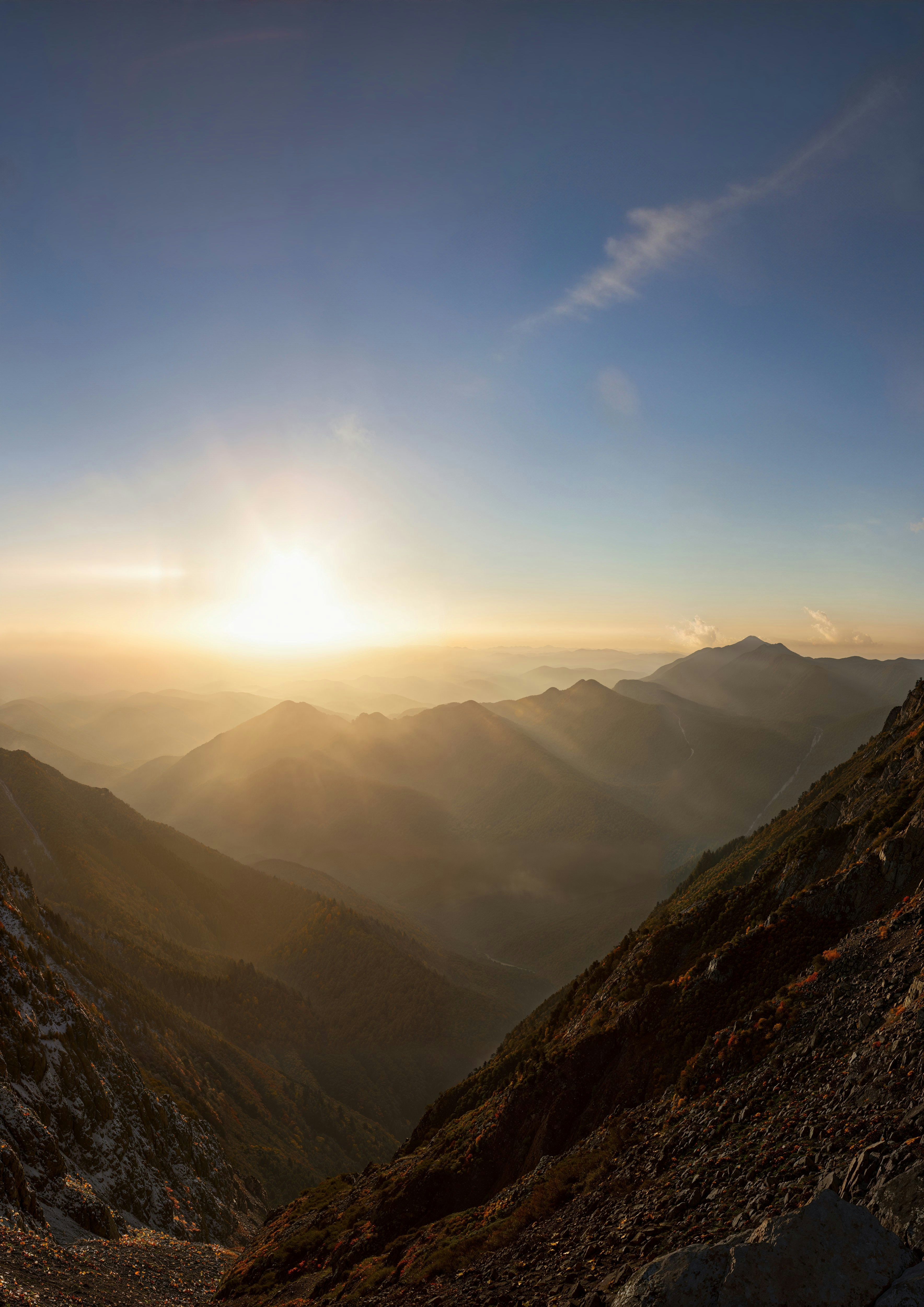 the sun is setting over a mountain range