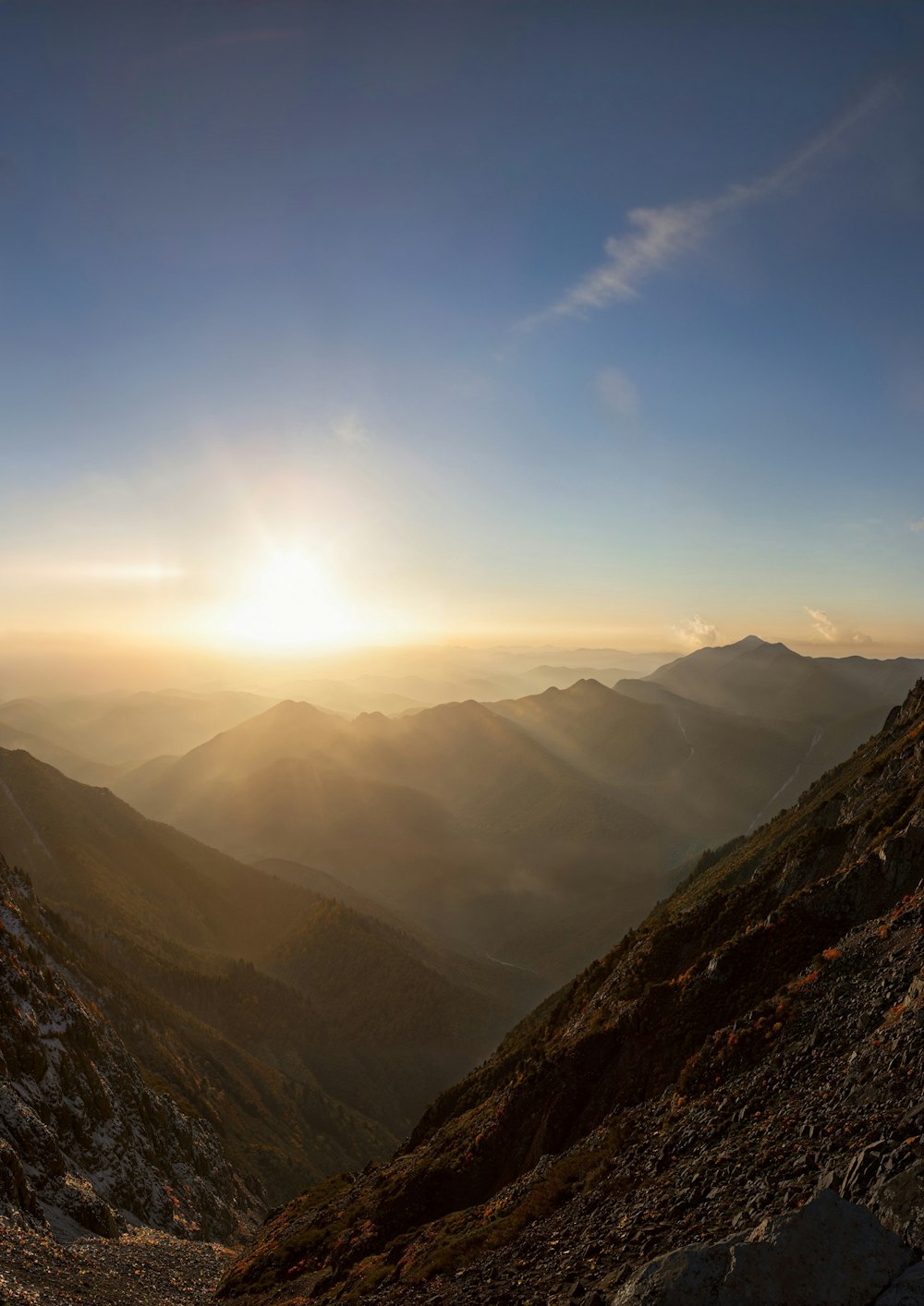 the sun is setting over a mountain range