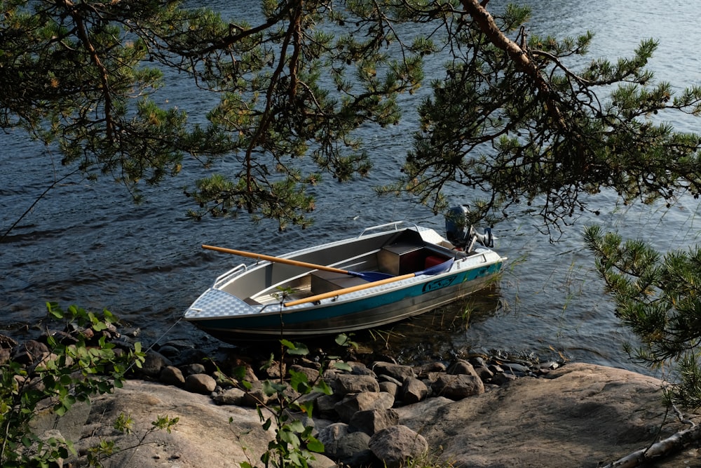 a small boat sitting on the shore of a lake