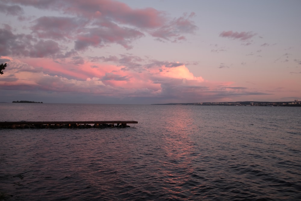 a body of water with clouds in the sky