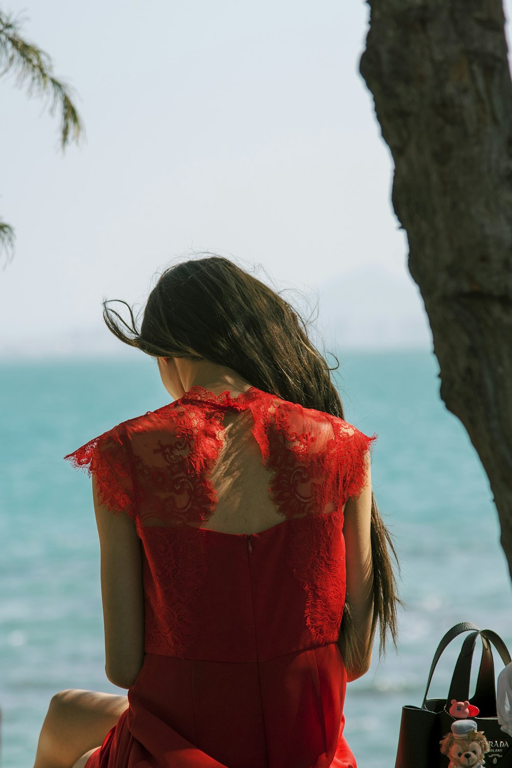 a woman in a red dress sitting on a bench