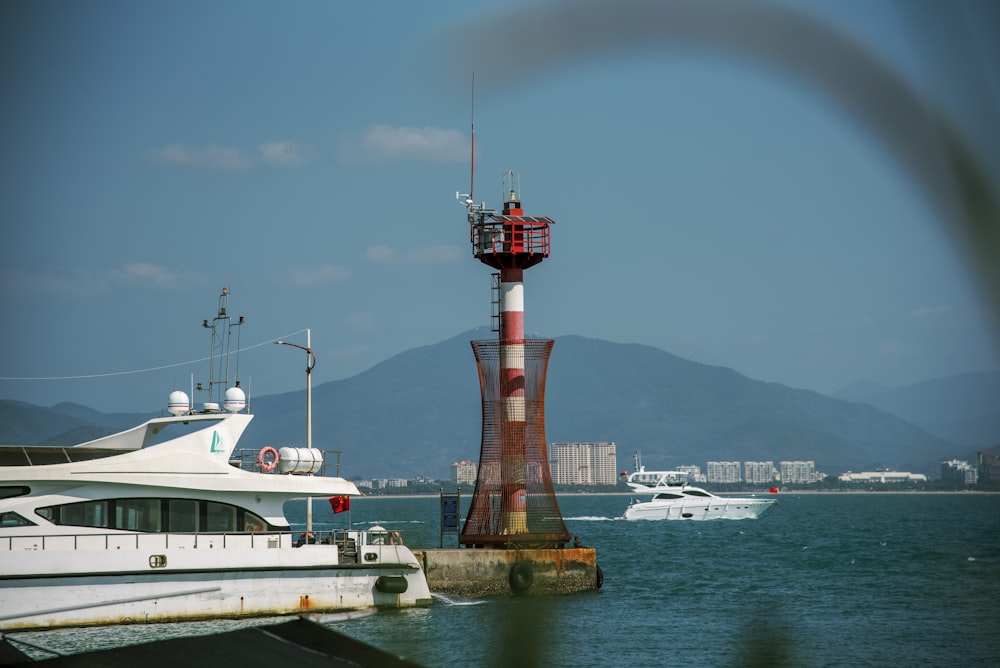 a boat is in the water near a lighthouse