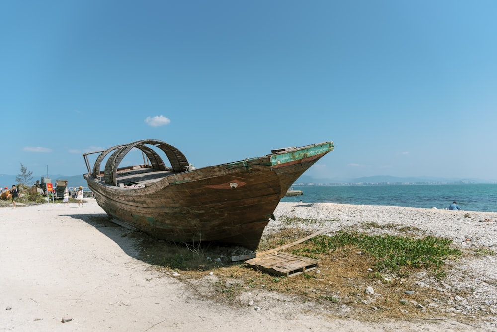 a boat sitting on top of a sandy beach