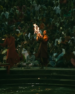 a crowd of people watching a man perform a fire show