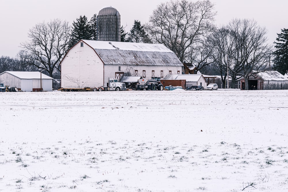 a barn in the middle of a snowy field