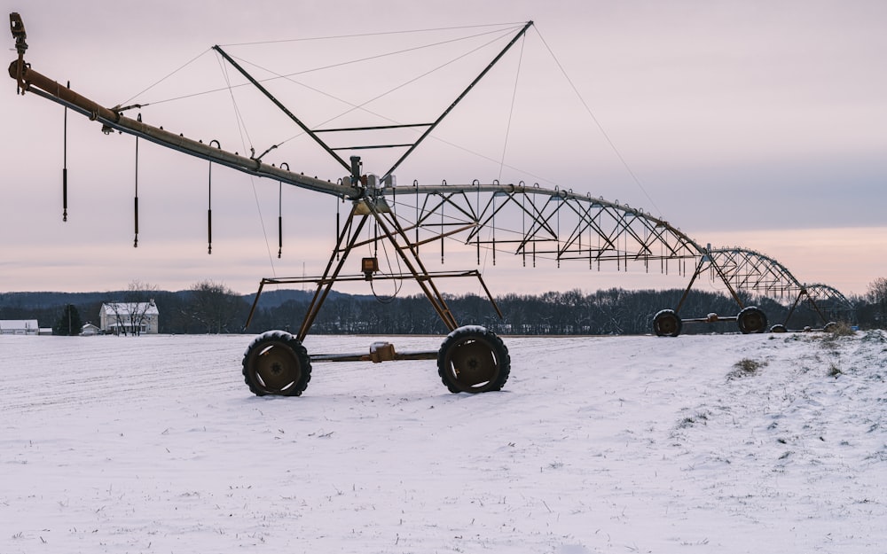 a large metal structure sitting on top of a snow covered field