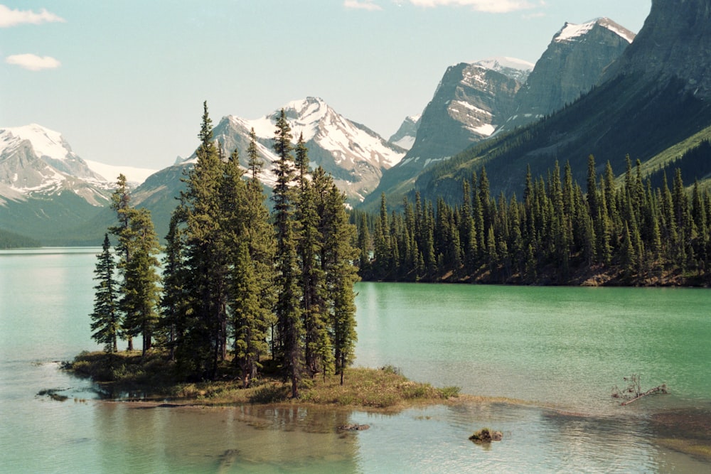 a small island in the middle of a lake surrounded by mountains