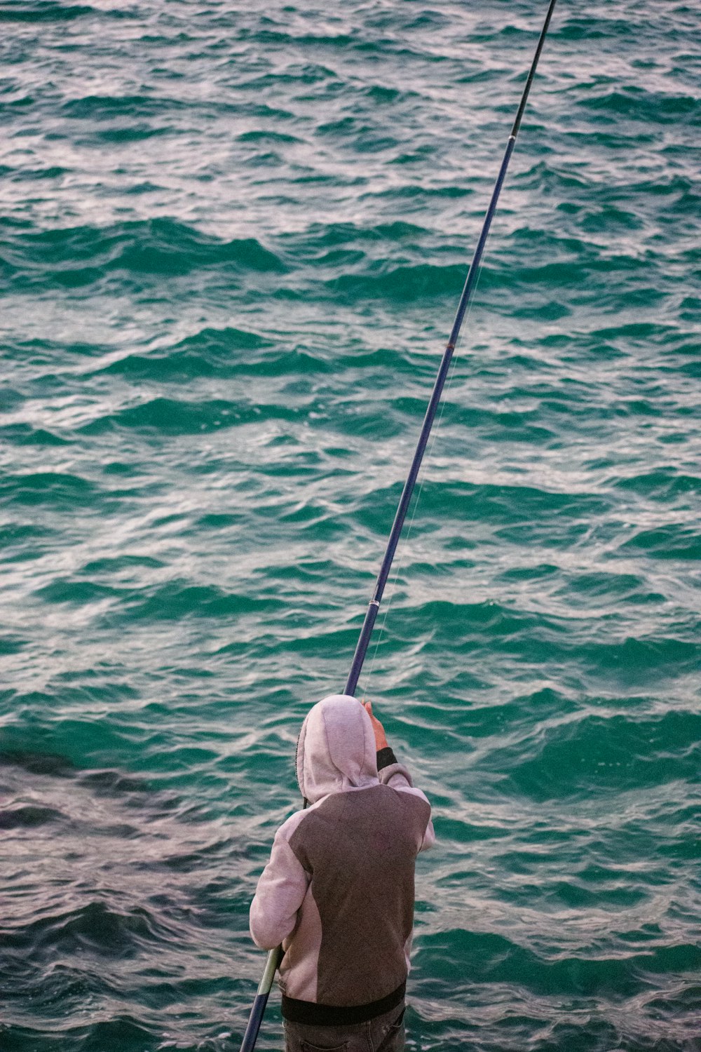 a person is fishing in the water with a pole