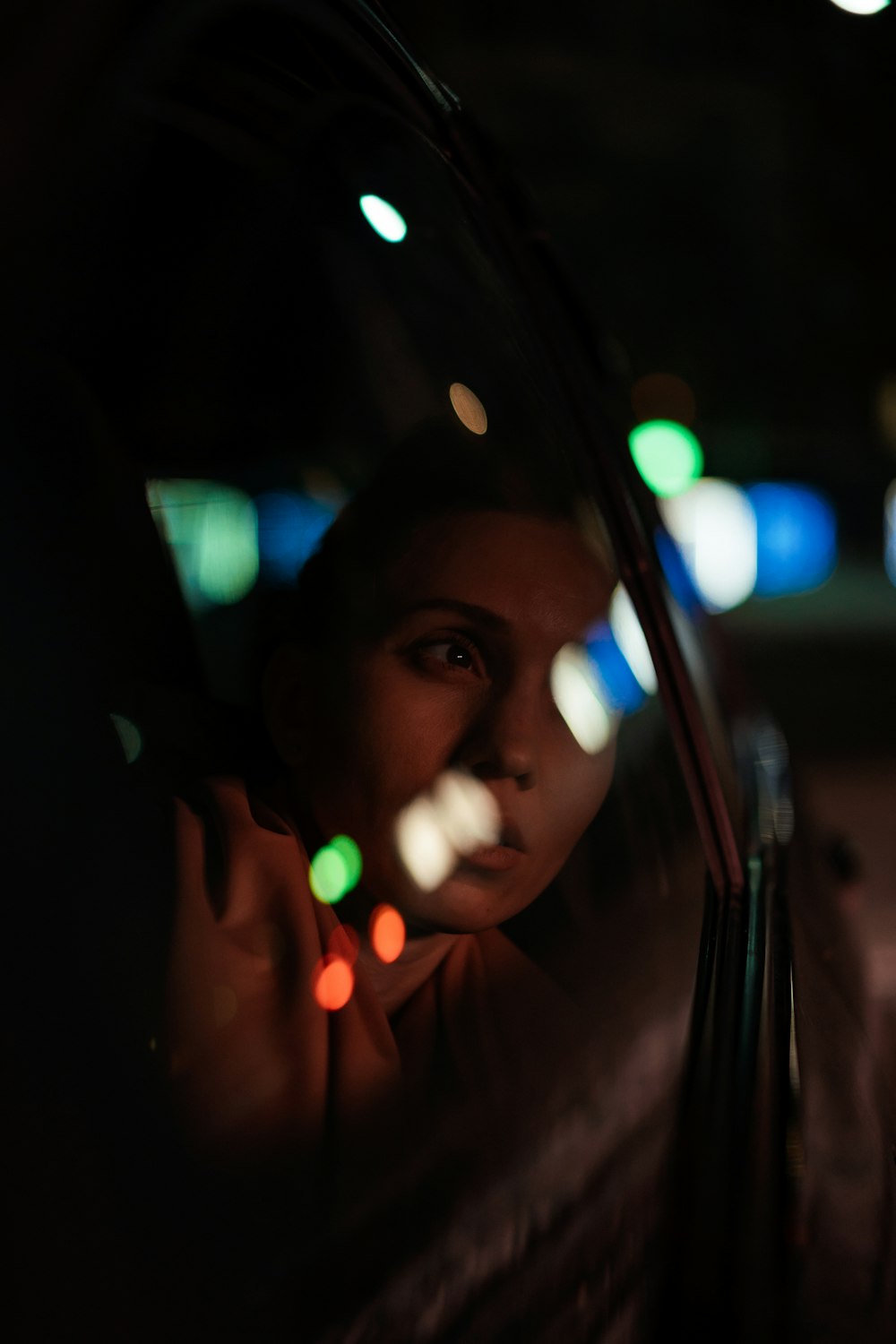 a woman is looking out the window of a car