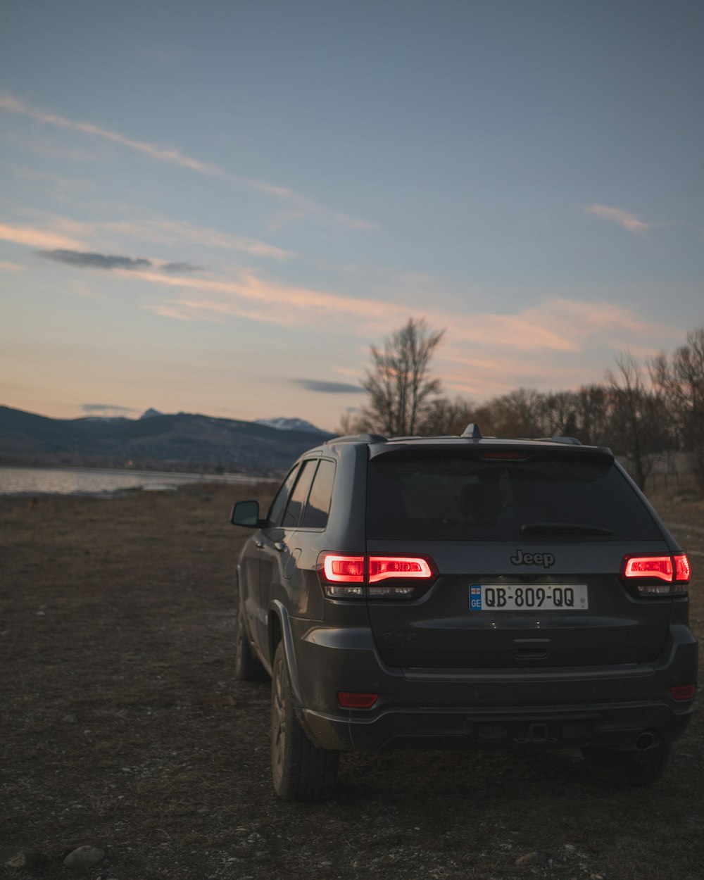 the back end of a car parked on a dirt field