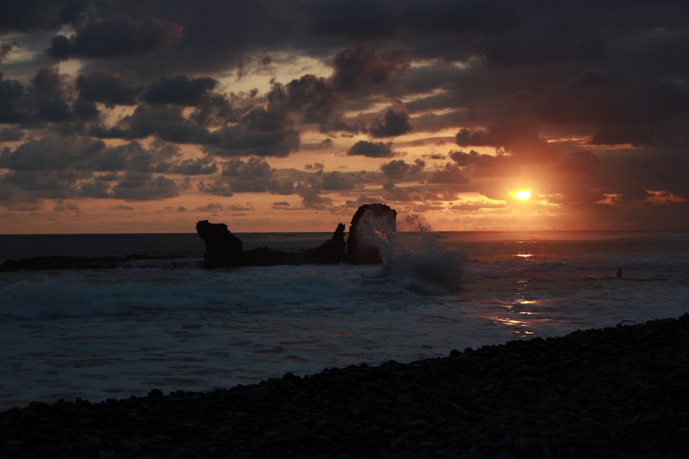 the sun is setting over the ocean with waves