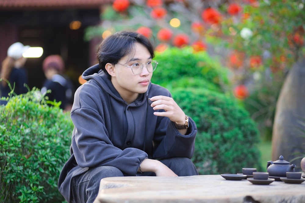 a man sitting at a table with tea cups