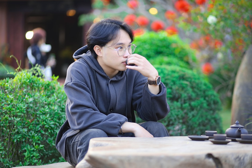a man sitting on a bench talking on a cell phone