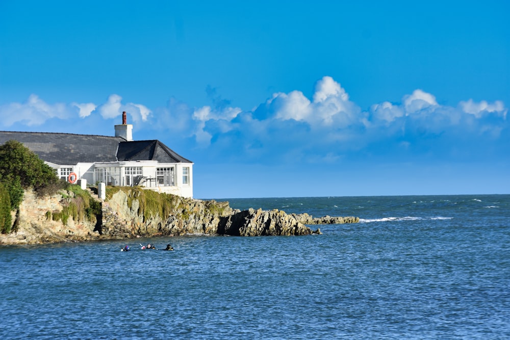 a house sitting on top of a cliff next to the ocean