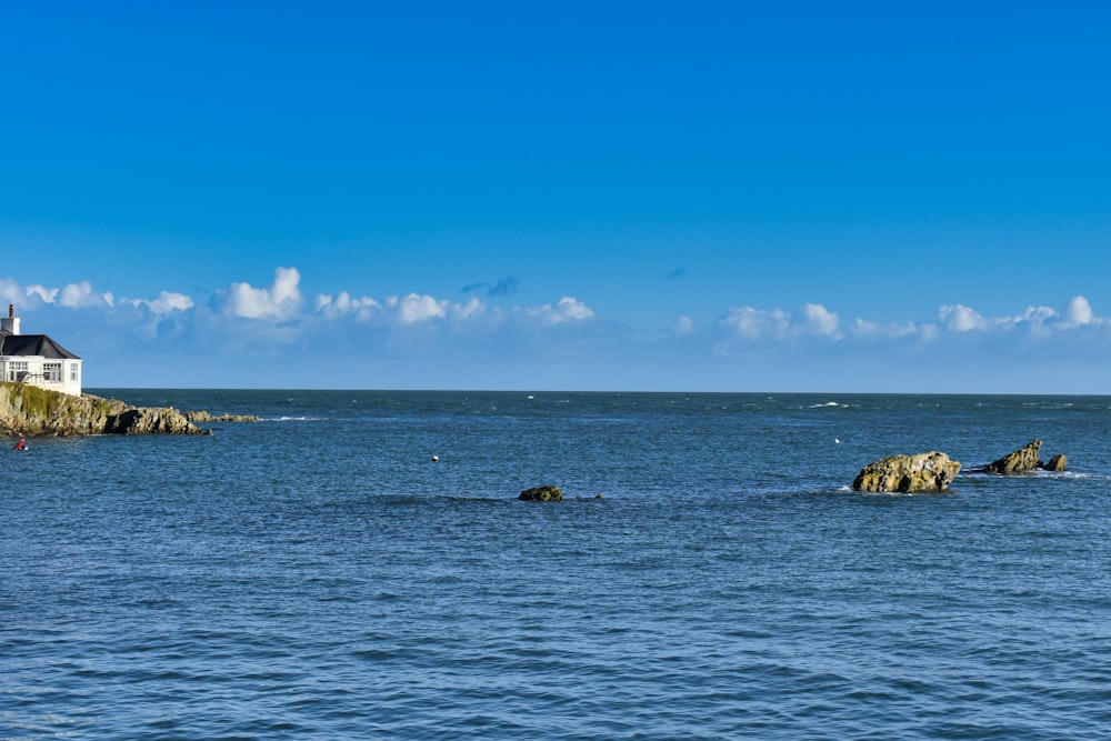 a house on a rock outcropping in the middle of the ocean