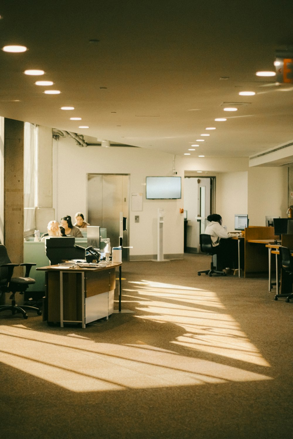 a large open room with people working on their computers