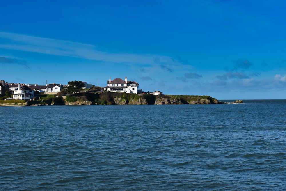 a large body of water with houses on a hill in the background