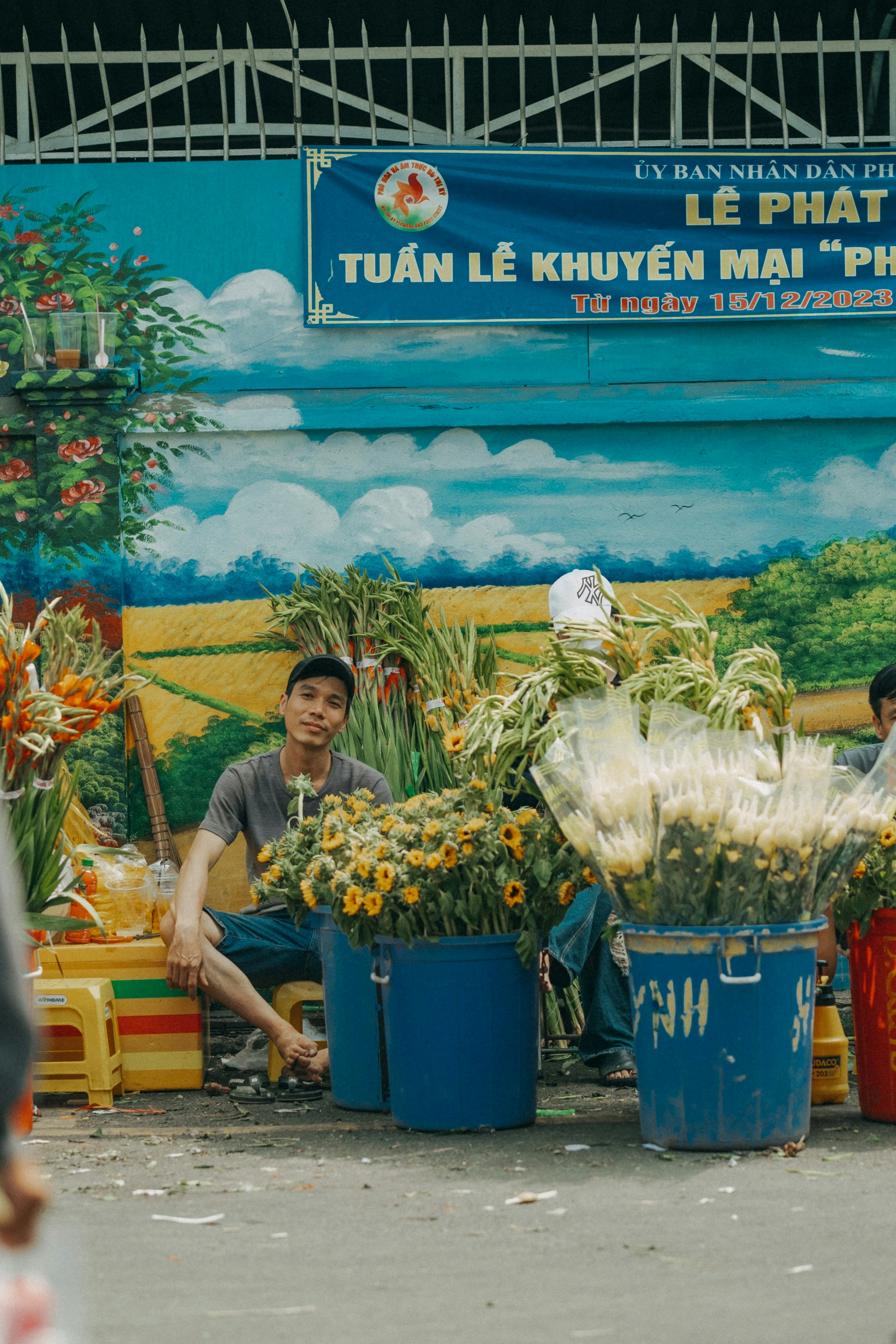 a man sitting in front of a bunch of flowers