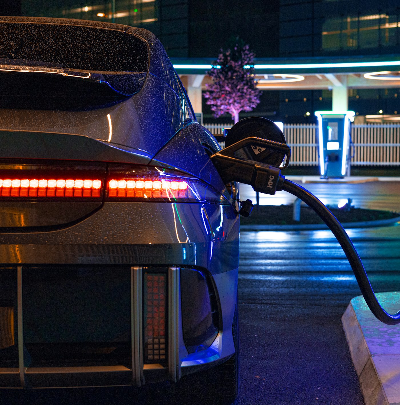 Electric vehicle charging at a modern station at night