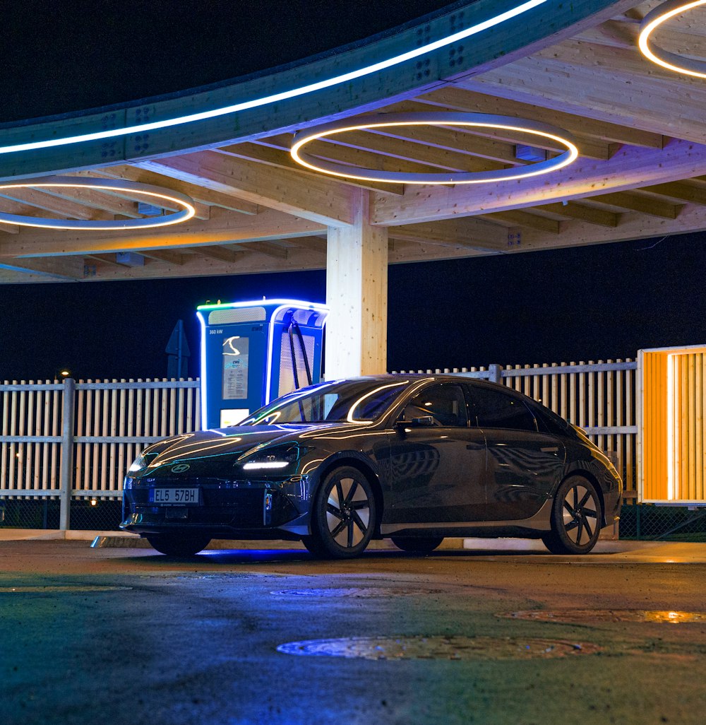 a black car parked in front of a gas station