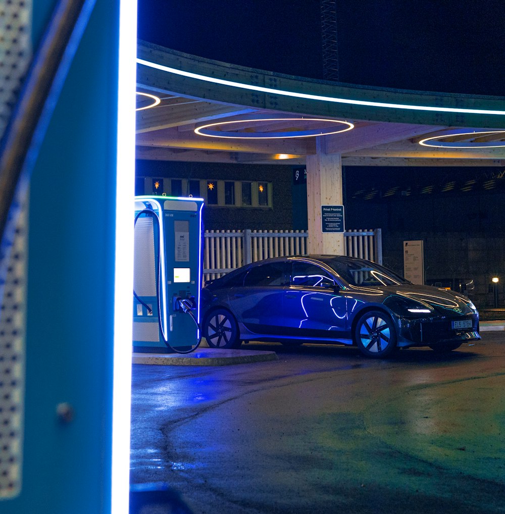 a blue car is parked at a gas station