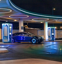 a blue car parked in front of a gas station