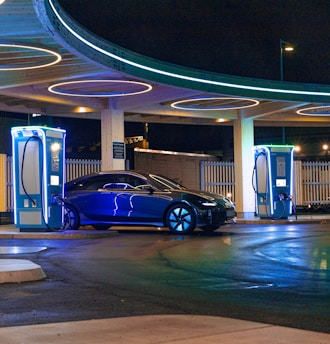 a blue car parked in front of a gas station