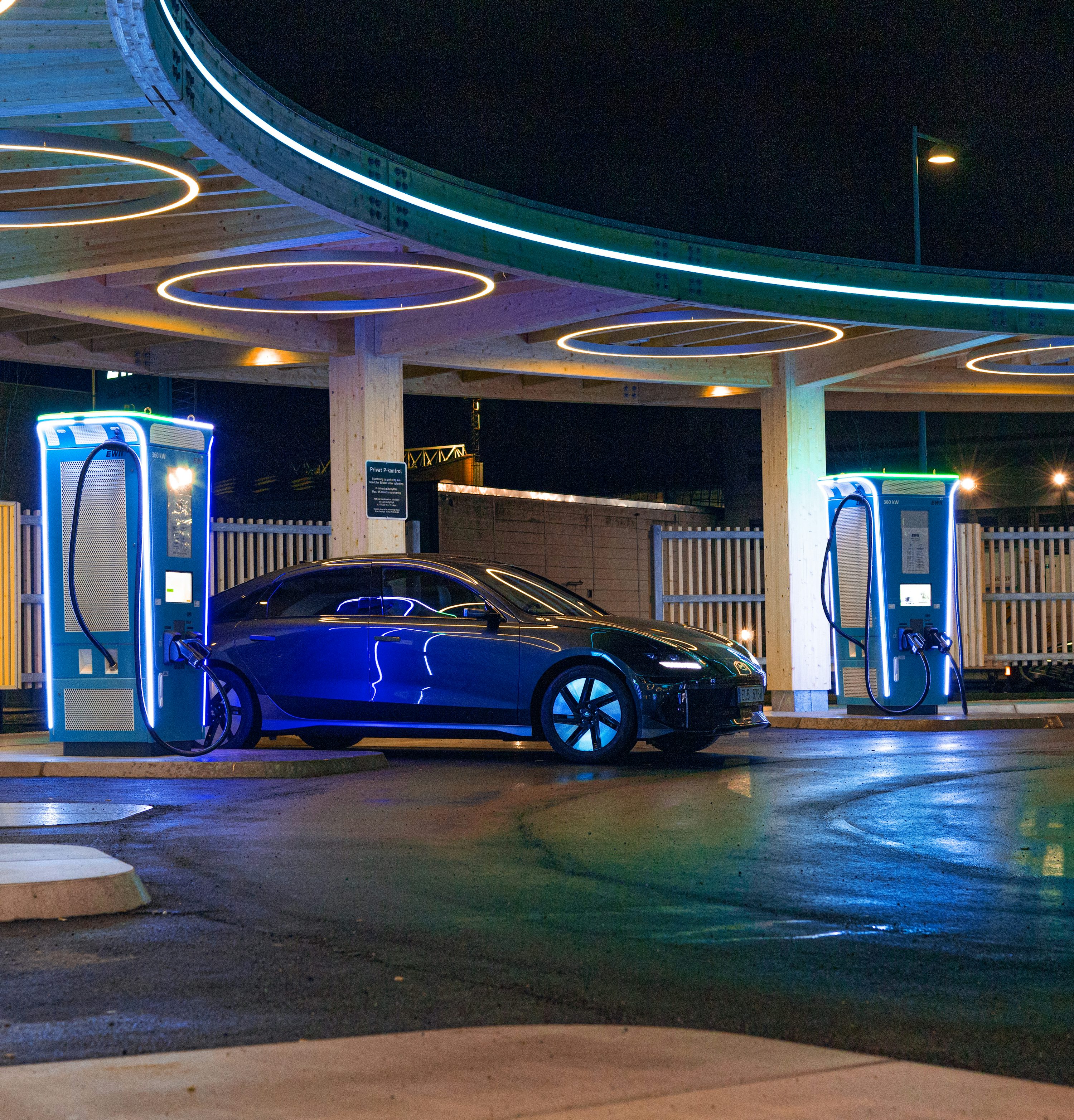 a blue car parked in front of a gas station