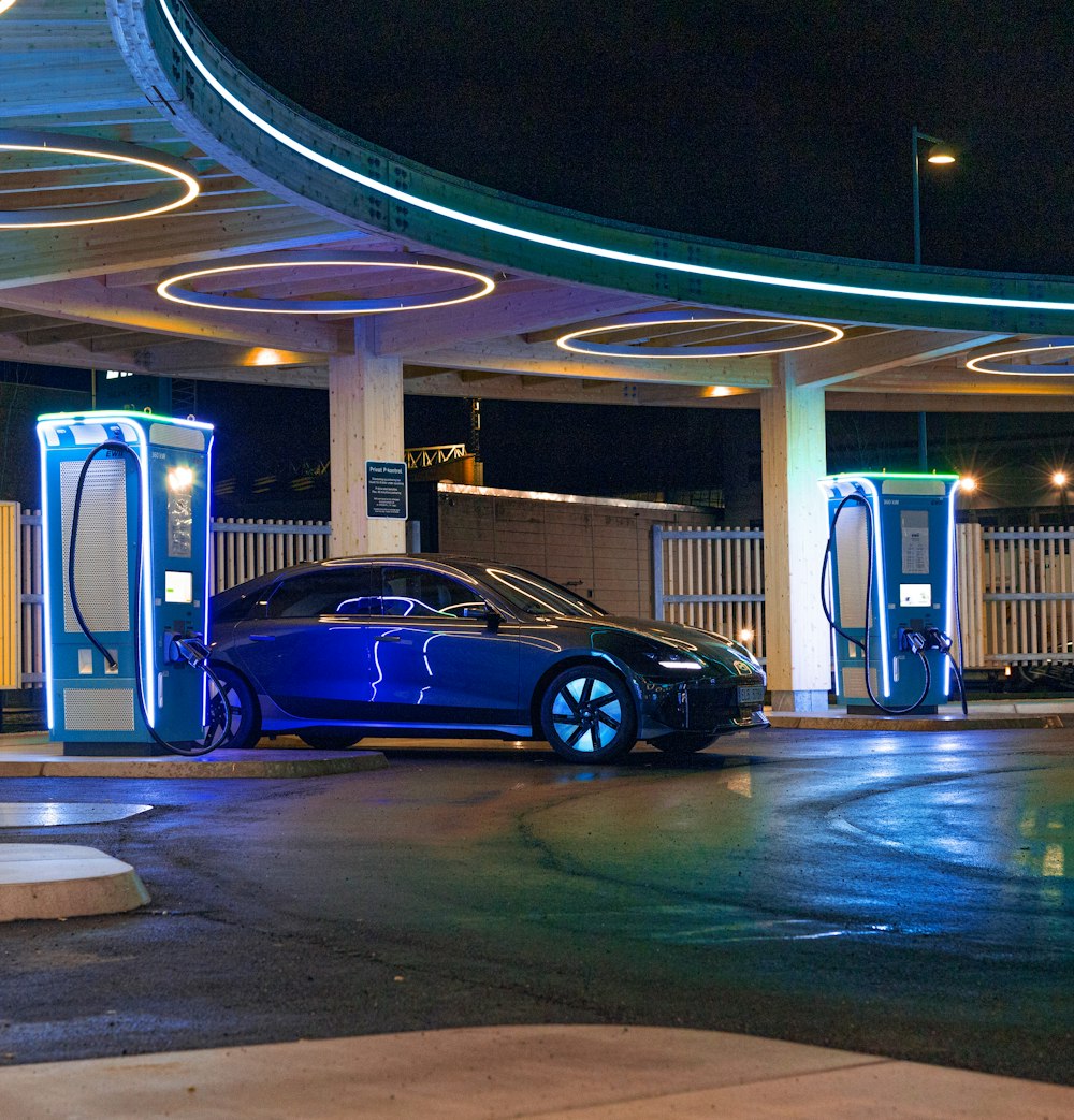 a blue car parked in front of a gas station