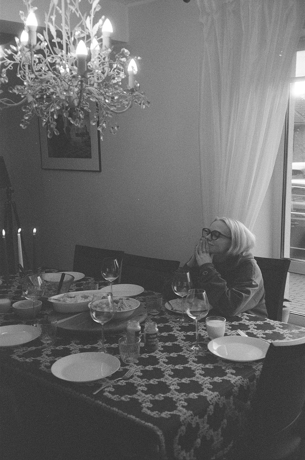 a woman sitting at a table with a glass of wine