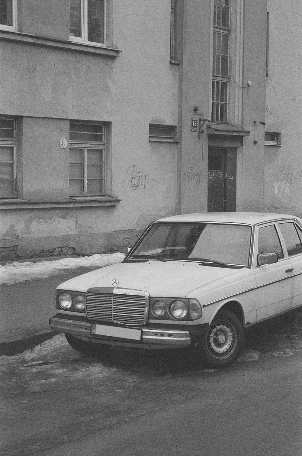 a white car parked in front of a building