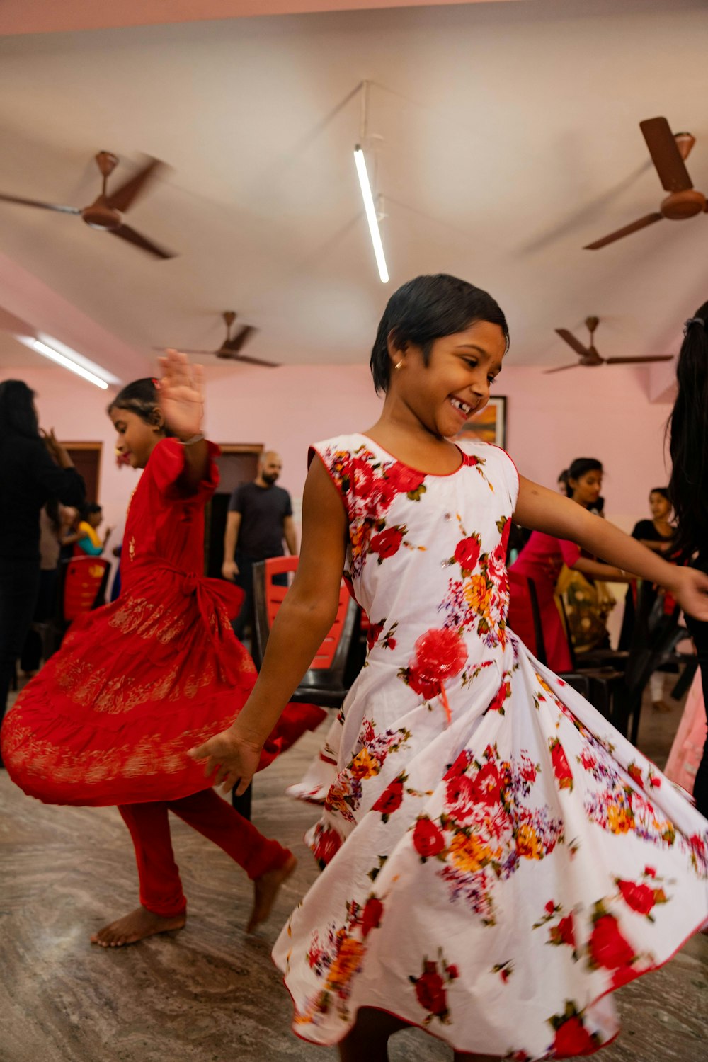 a young girl in a red and white dress dancing
