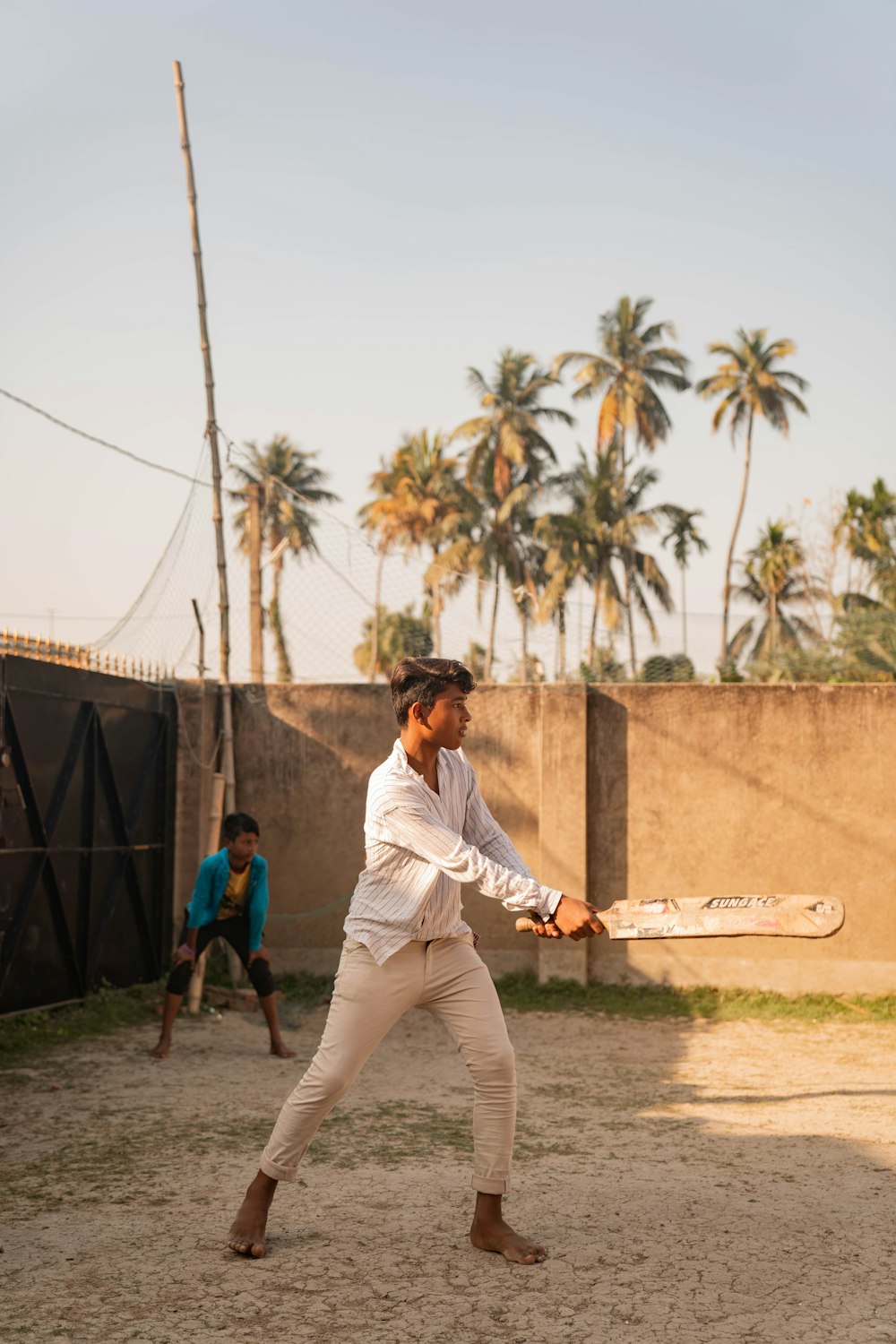 a man swinging a baseball bat on a dirt field