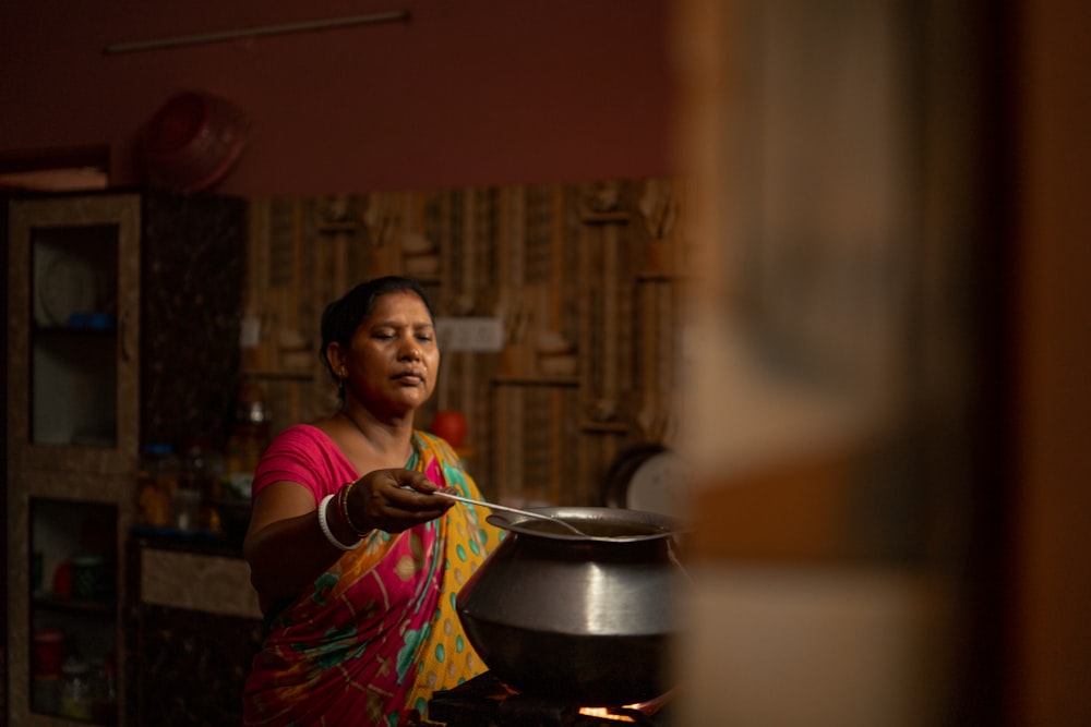 a woman stirring a pot on a stove