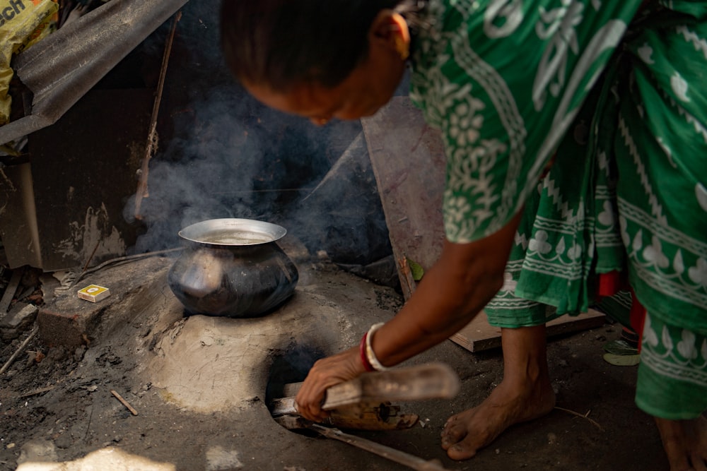 a woman cooking food over an open fire