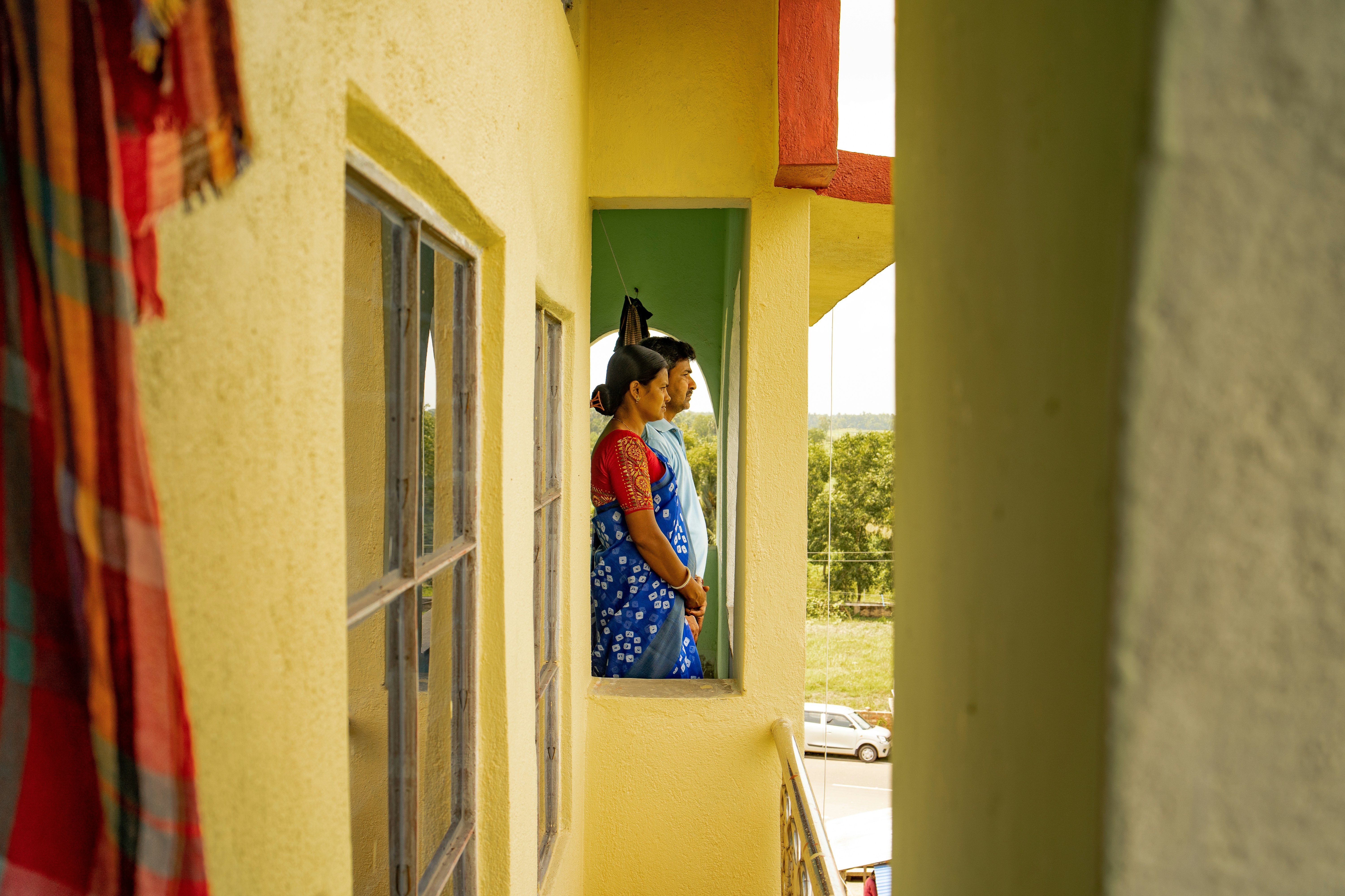 a woman in a blue dress looking out a window