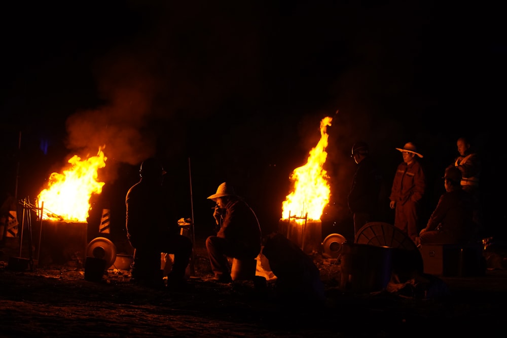 a group of people standing around a fire