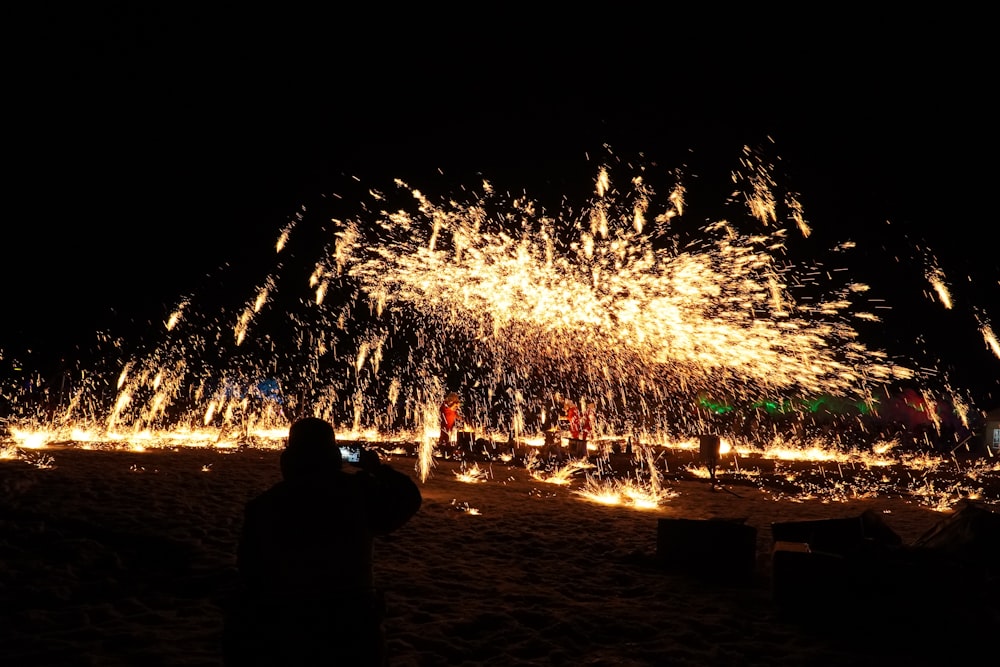 a person taking a picture of a firework display