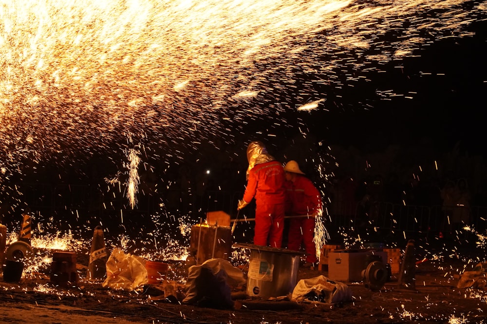 a man in a red coverall standing next to a fire hydrant