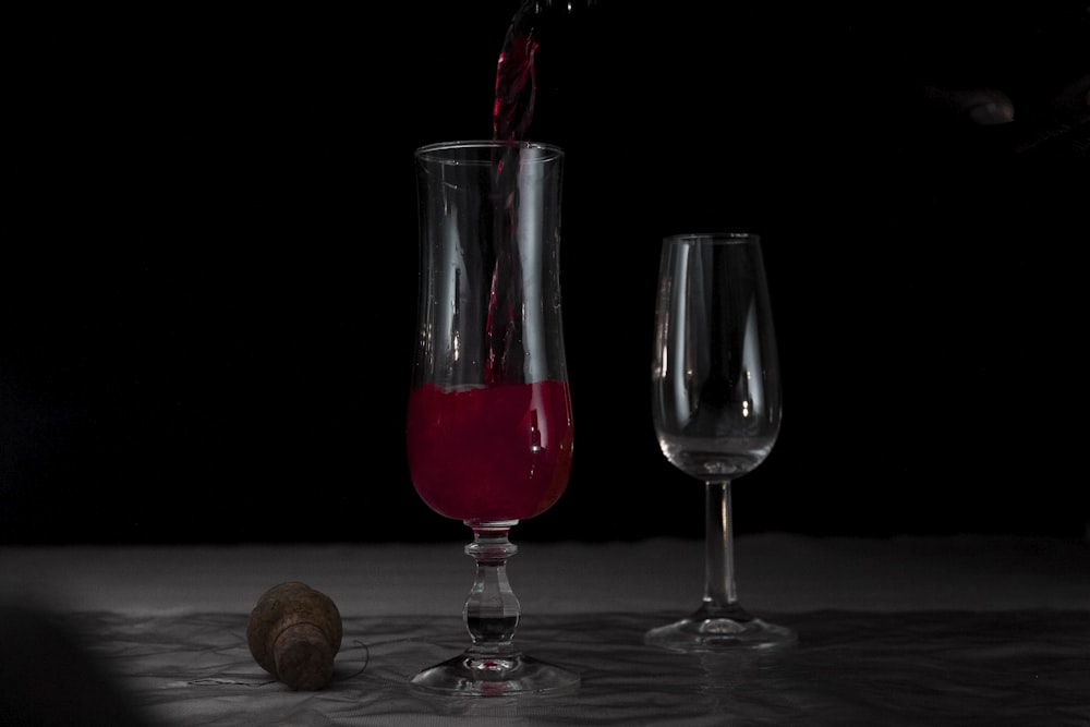 a glass of wine being poured into a wine glass