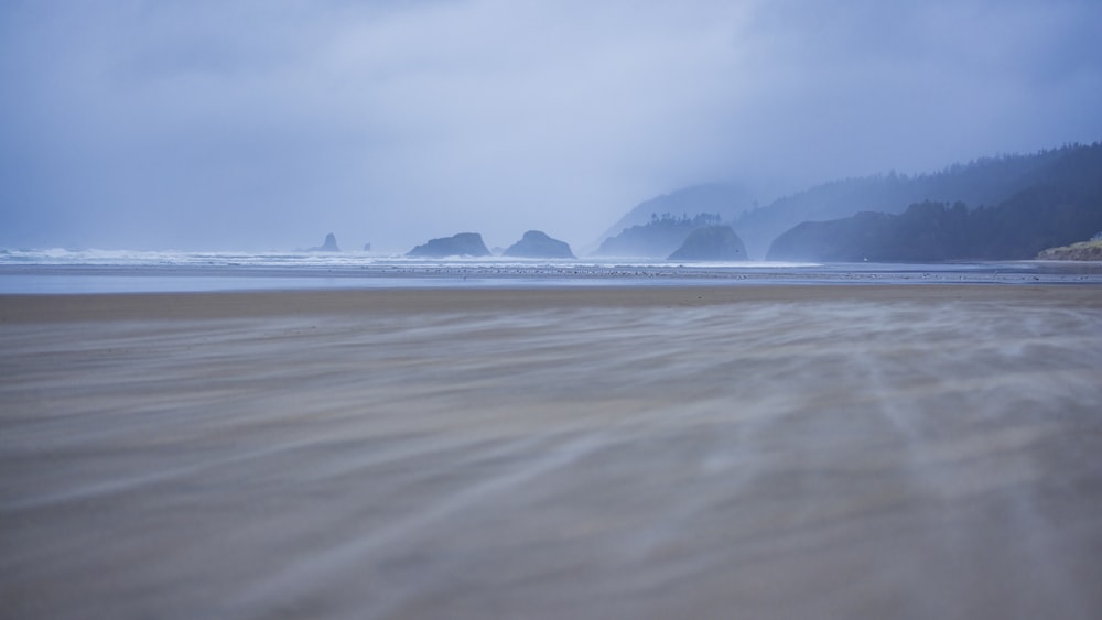 a sandy beach with waves coming in to shore